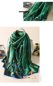 Détail de l'écharpe effet soie avec motif plumes de paon et bordure bleu foncé