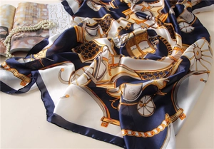 Detailed view of luxury silk scarf with vintage carriage print and gold chain patterns