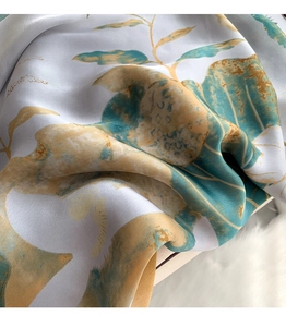 Close-up of floral silk scarf with elegant lotus print and smooth satin texture