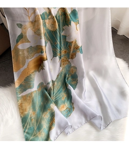 Detail of elegant satin scarf with lotus print and fine rolled edges on soft background