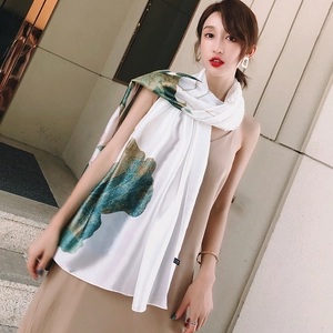 Elegant white silk-like shawl with artistic lotus and lily pad print worn as a wrap