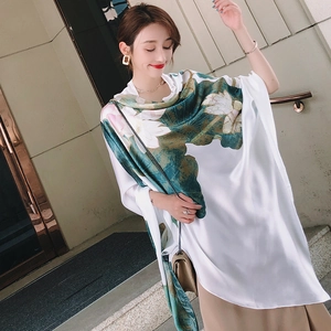 Detail of silk-like scarf featuring elegant lotus floral prints and smooth texture