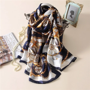 Elegant silk scarf with classic carriage print draped over a stylish grey handbag
