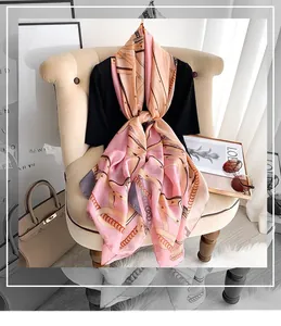Detail of pink-orange silk scarf with elegant retro chain print and polka dot pattern