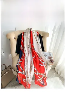 Detail of elegant chain print silk scarf draped over a chair in a classic style