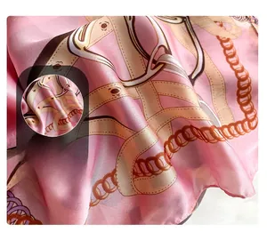 Detailed view of pink silk scarf showing premium stitching and chain print texture