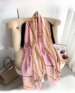 Detail of silk scarf with chain and harness patterns draped on a vintage chair