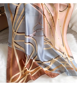 Luxurious silk scarf detail featuring elegant chain and harness print on smooth fabric