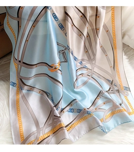 Macro detail of silk texture long scarf featuring chain and horse harness print pattern