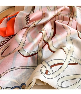 Close-up of silk scarf with vintage chain patterns and soft fabric draping texture