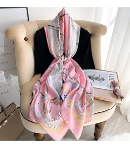 Detail of elegant pink silk scarf with classic chain and equestrian harness print