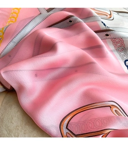Macro shot of elegant pink chain print silk scarf with smooth glossy texture and drapes