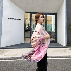 Detail of elegant chain print silk scarf showing long drape and soft satin texture