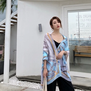 Detail of silk-feel long scarf featuring classic chain prints and elegant blue pattern
