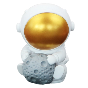 Astronaut piggy bank holding a grey moon model with a metallic gold helmet visor