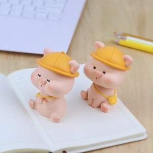 Cute pink shaking head pig ornaments on a white notebook for car and desk decor