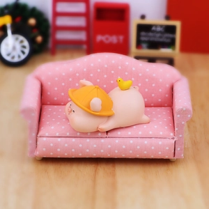 Miniature de cochon mignon sur canapé à pois roses pour décoration de bureau