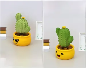Macro shot of resin cactus bobblehead dashboard ornament with spring and hand-painted details