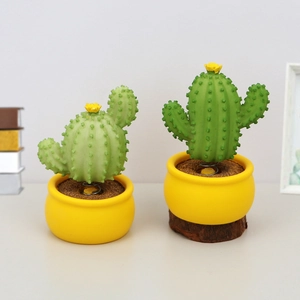 Detail view of two green bobblehead cactus figurines with yellow flower and spring base
