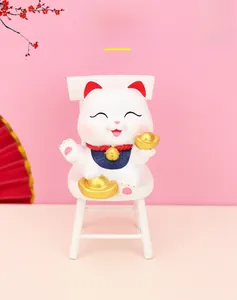 Macro view of Maneki Neko sitting on a white chair with gold ingots and festive decor