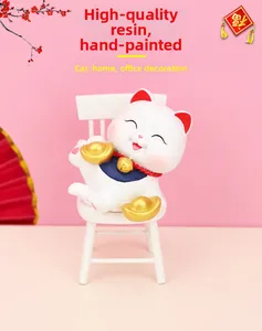 Close-up of hand-painted resin lucky cat figurine with gold ingot on a white chair