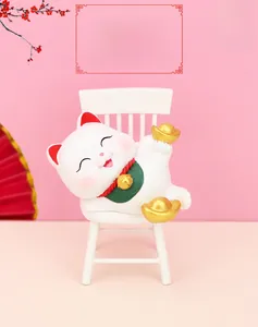 Close-up of a Fortune Cat resin figurine holding gold ingots on a pink festive background