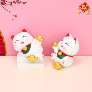 Detail of lucky cat resin ornaments with golden ingots for car and home decor