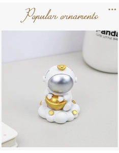 Detail der Astronauten-Figur mit Goldbarren auf Wolkenbasis für den Schreibtisch
