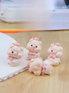 Detail of four cute resin pig figurines in diverse poses for home and office desktop decor