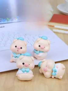 Detail of four cute cartoon pig figurines with blue sailor hats on a white laptop