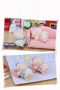 Close-up of cute resin pig figurines in miniature scenes for desktop decoration