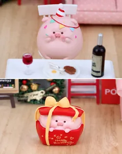 Detailansicht süßer rosa Schweinefiguren mit Partyhut und roter Geburtstagsbox