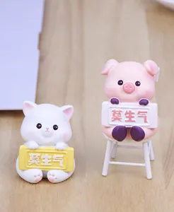 Detailed view of cute cat and pig miniature figurines with Mo Sheng Qi sign for car and desk