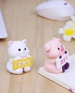 Close-up of cute resin cat and pig desktop ornaments with Mo Sheng Qi slogan