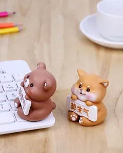 Detailed view of cute resin animal figures holding signs on a creative office desk setup