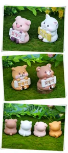 Detail view of four cute resin animal figurines holding signs on a green lawn