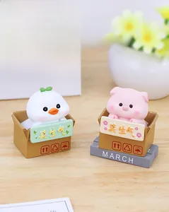 Detail of cute cat and pig resin ornaments sitting in Mo Sheng Qi cardboard boxes