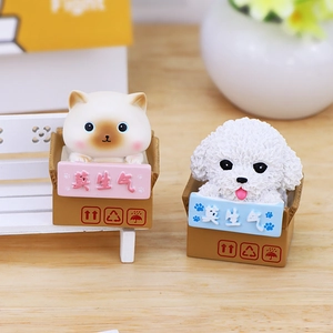 Cute resin cat and dog figurines in cardboard boxes on a desk for home car decor