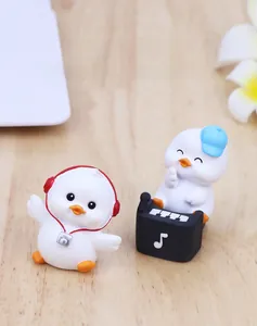 Detail of cute duck figurines with headphones and piano on wooden desk surface