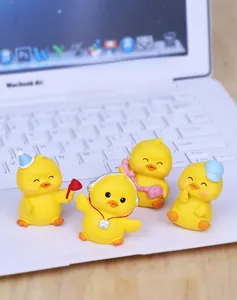 Set of four cute yellow duck resin figurines with accessories on office desk setup
