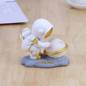 Astronaut night light with golden accents on lunar base for cozy desktop decor