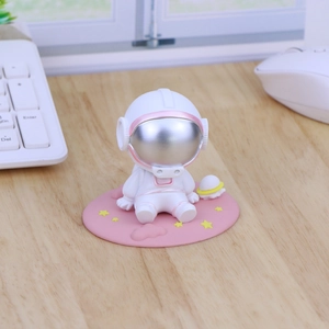 Pink astronaut car ornament with silver helmet visor sitting on a starry round base