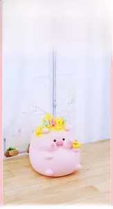 Detailed close-up of a pink cartoon pig money box with a crown and a small yellow duck