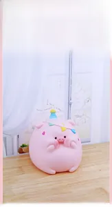 Close-up of a cute pink pig piggy bank with a party hat on a cozy wooden table