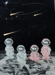 Detail of pink and white astronaut figurines holding a heart and rose on moon surface