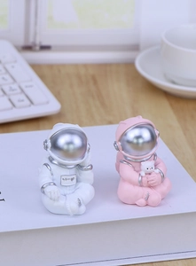 Close-up of cute white and pink resin astronaut figurines on a desktop for home decor