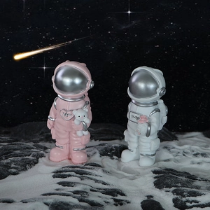 Creative astronaut figurines set with bear and rose on a moon-surface background