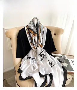 Detail showing elegant faux silk scarf texture with abstract print and sleek black edges