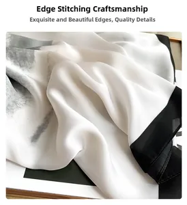 Detail shot of black and white silk scarf showing high-quality overlock stitched edges