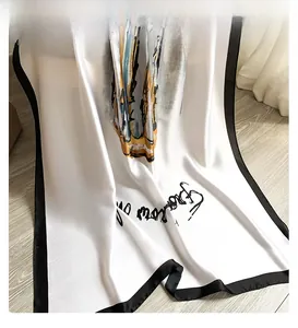 Close-up of elegant faux silk scarf with abstract patterns on light wood background